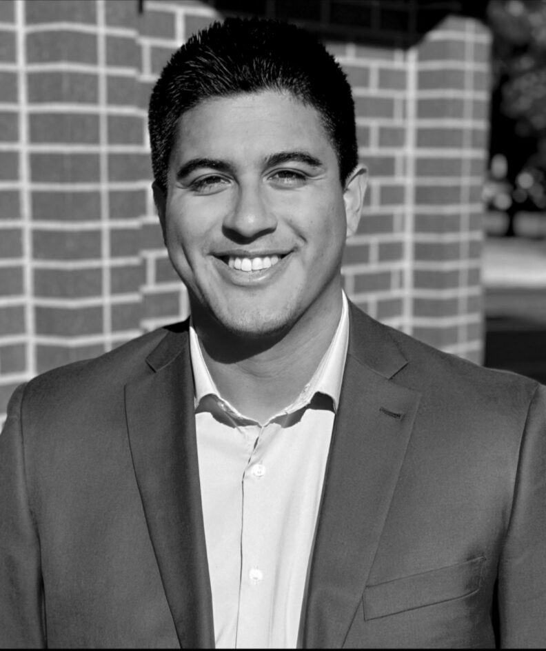 Black and white photos of Fisher\SMB Retirement Counselor, Jose Leyva standing in front of brick wall.