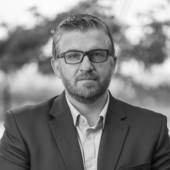 Black and white image of man in blazer. This is Casey Chajkowski's bio.