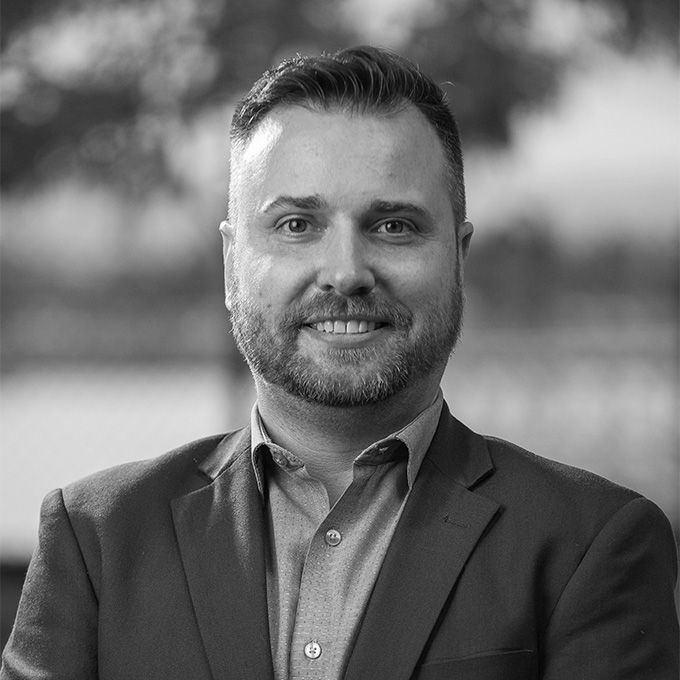 Black and white image of man in blazer. This is Chris Edar Allred's bio.