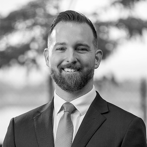 Black and White photo of white middle aged man wearing a blazer. This is Greg Grooms's bio.