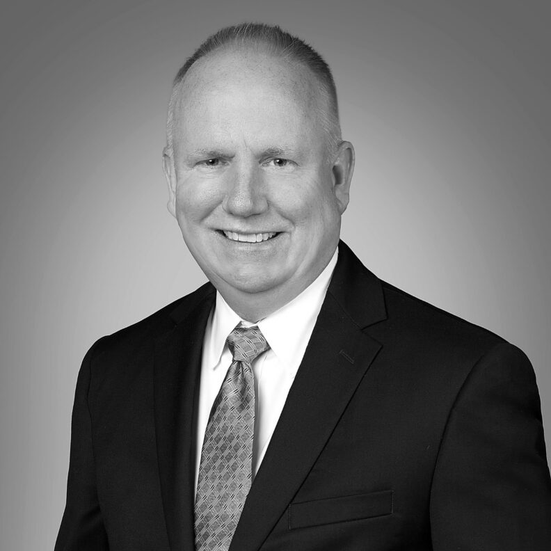 Photo of white man in a blazer and tie smiling. This is Jason Brantley's biography.