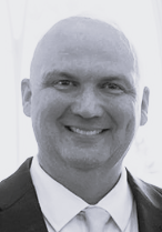 Black and white photo of a middle aged white male in a button up shirt and blazer. This is Bryan Satterfield's bio.
