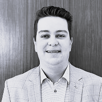 Black and white old of a man in a button up shirt and blazer. This is Connor Miller's bio